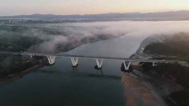 Vila Nova de Milfontes Bridge In Morning Fog Over River Mira In Odemira, Portugal. aerial shot