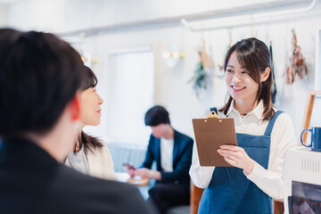 カフェで注文を取る若いスタッフ