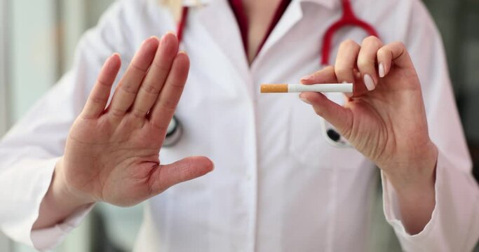 Doctor shows stop gesture and holds cigarette