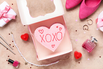 Heart-shaped bento cake with gift boxes and stylish heels on grunge pink background. Valentine's...