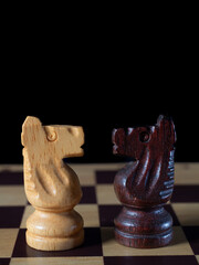 Two knights facing each other on a chess board.