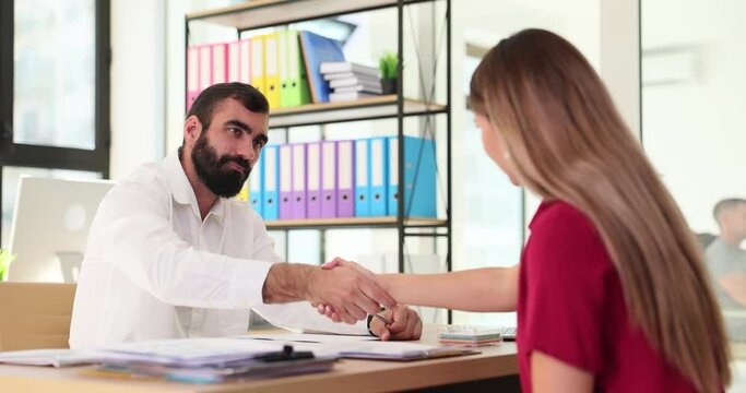 Confident female candidate undergoes interview, completes official appointment and shakes hands with company HR manager