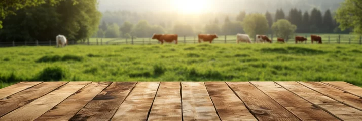 Fotobehang Empty wooden boardwalk over blurred pasture with cows and green grass background. banner, panorama, mock up for product display. © MaskaRad