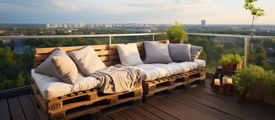 A wooden pallet couch is placed on a balcony, adding a rustic touch to the outdoor space. The balcony overlooks the surrounding area, with the couch positioned for relaxation and outdoor enjoyment.