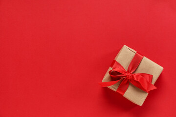 Gift box with ribbon on red background. Valentine's Day celebration