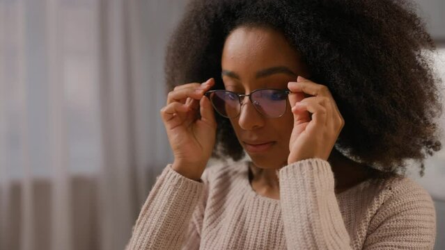 Close up female African American woman wearing glasses eyeglasses vision problem medicine eyesight businesswoman working at home looking at laptop screen pc computer monitor reflection in spectacles