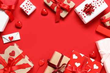 Frame made of beautiful gift boxes and candies on red background. Valentines Day celebration