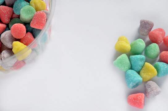 Pastillas de goma de yogur colores pastel recubiertas de az&uacute;car sobre un fondo blanco donde se puede escribir un mensaje 