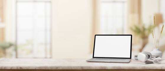 A marble desk with a laptop mockup set against the blurred background of a modern home office.
