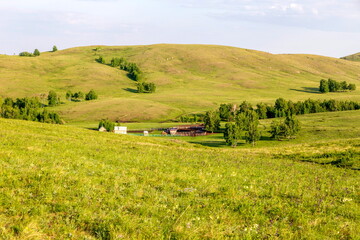 Fototapeta na wymiar small farm in the mountains of the Southern Urals on a sunny summer day