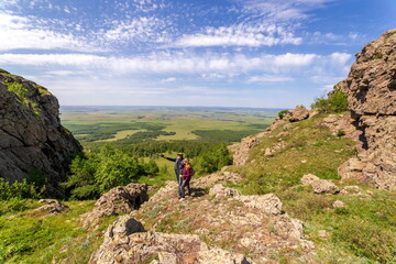 happy mature married couple traveling through the Ural mountains on a summer day