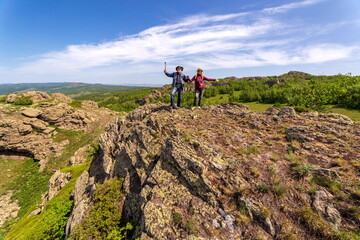 happy mature married couple traveling through the Ural mountains on a summer day