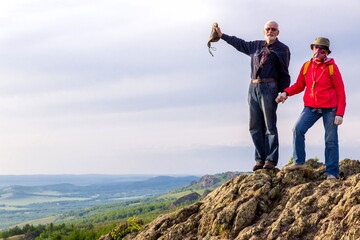 happy mature married couple traveling through the Ural mountains on a summer day