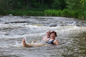 sports elderly couple bathes in the mountain river Sakmara in the Southern Urals