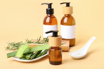 Set of bottles with natural cosmetic products, enzyme powder in spoon, rosemary and aloe leaves on...