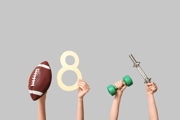 Female hands with paper figure 8 and sports equipment on grey background. International Women's Day