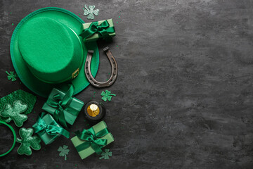 Leprechaun hat with gift boxes, clovers and horseshoe on black grunge background. St. Patrick's Day