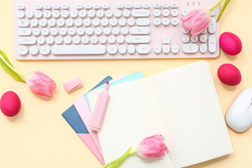 Easter eggs, notebook, tulips, marker, computer keyboard and mouse on yellow background