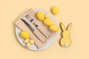 Beautiful table setting with Easter eggs and bunny on yellow background