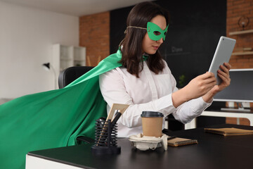 Business woman dressed as superhero with tablet computer in office © Pixel-Shot