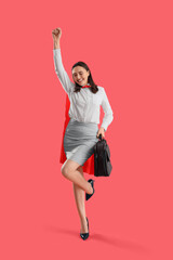 Happy businesswoman with superhero cape on red background