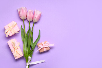 Gift boxes and pink tulips on lilac background. Top view
