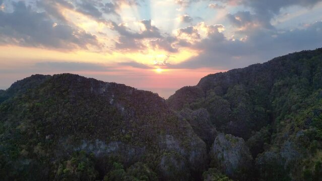 Majestic sunset over rugged mountain peaks. Smooth aerial top view flight tilt down drone
4k footage