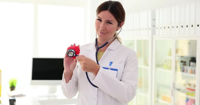 Cardiologist uses stethoscope to listen to heartbeat sounds of anatomical model