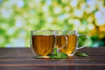 glass cup of natural organic herbal tea on a wooden table