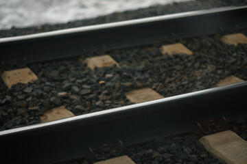 Closeup of worn, weathered steel rails of train tracks in the Sierra Nevada mountains. They are laid on gravel, to add stability and facilitate weight distribution. 