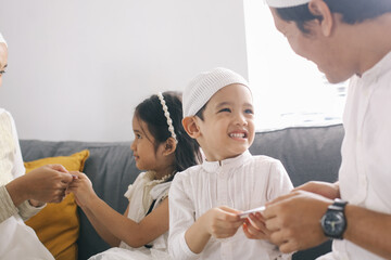 Muslim parents give money to their children during Eid Al Fitr. Indonesian tradition during Eid...