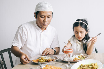 Muslim family enjoying special food at dining room during Eid Mubarak moment.