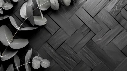 Evoking a sleek and modern aesthetic, dark eucalyptus leaves sprawl gracefully over a black herringbone patterned surface. - obrazy, fototapety, plakaty