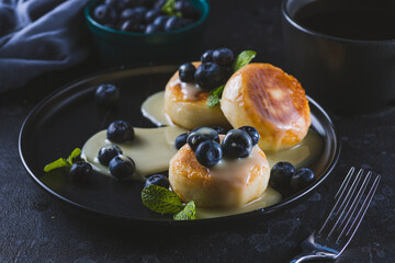 Cheesecakes served with berries and condensed milk