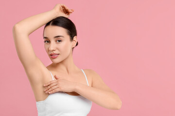 Beautiful woman showing armpit with smooth clean skin on pink background, space for text