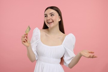 Happy woman with credit card on pink background