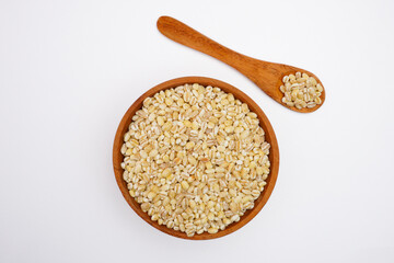 Dry pearl barley in the bowl and the spoon concept background