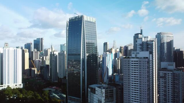 Aerial view circling in front of the Makati city skyline, in sunny Manila, Philippines