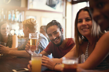 Friends, man and smile in pub with beer for happy hour, relax or social event with confidence. Diversity, people and drinking alcohol in restaurant or club with discussion for bonding and celebration - obrazy, fototapety, plakaty