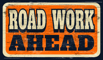 Old worn road work ahead sign on wood