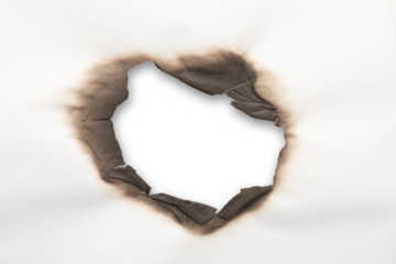 A charred, irregular hole through white paper, revealing a stark white backdrop.