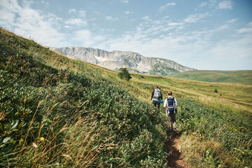 A tourist walks along a trail in the mountains. A high-altitude region. The Caucasus Mountains....