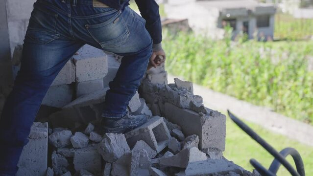 bricklayer tearing down a wall