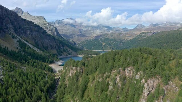 Lago di devero in alpe devero with lush forests and rugged mountains, aerial view