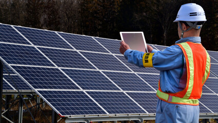 ソーラー発電施設の点検を行うエンジニア
