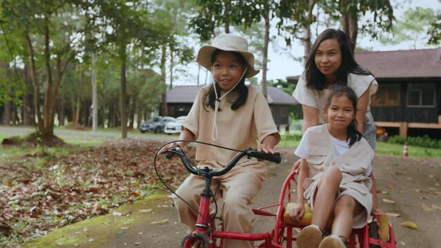Asian family riding the tricycle with cargo bike together.