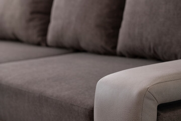 Close-up of a sofa in combined beige and gray shades. Interior upholstered furniture with velor...