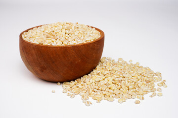 Dry pearl barley in the wooden bowl concept background