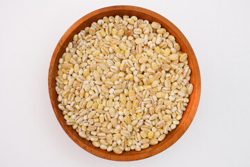 Dry pearl barley in the wooden bowl concept background