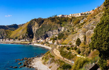 Panoramic view of Taormina shore at Ionian sea with Castello Saraceno castle, Giardini Naxos and Villagonia towns in Messina region of Sicily in Italy